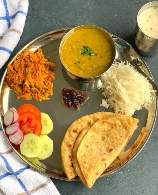 A traditional Indian plate: dal, sabzi, rice, roti, salad and curd